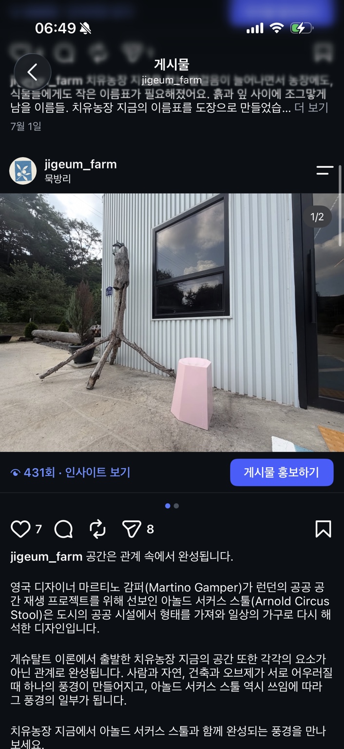 농장 건물 앞의 분홍색 아놀드 서커스 스툴